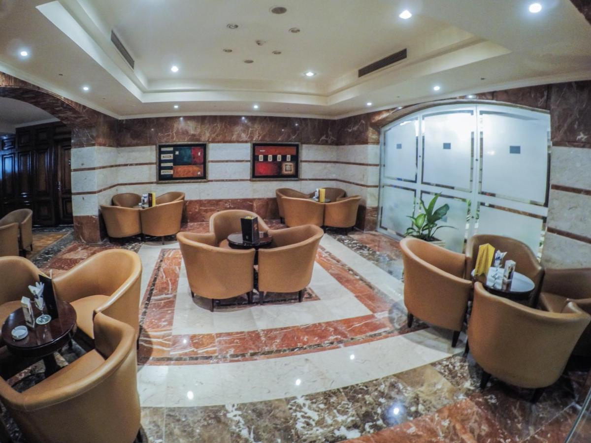 Sunrise Alex Avenue Hotel Alexandria Exterior photo The photo depicts a stylish lounge area with several comfortable seating arrangements. There are plush, curved chairs arranged around small tables, likely intended for coffee or casual gatherings. The floor features a polished marble design, and the 